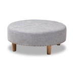 Otoman Mineta de la marca Hanabi Living, tapizado en tela gris, con estructura rectangular y cojín acolchado para asiento cómodo.